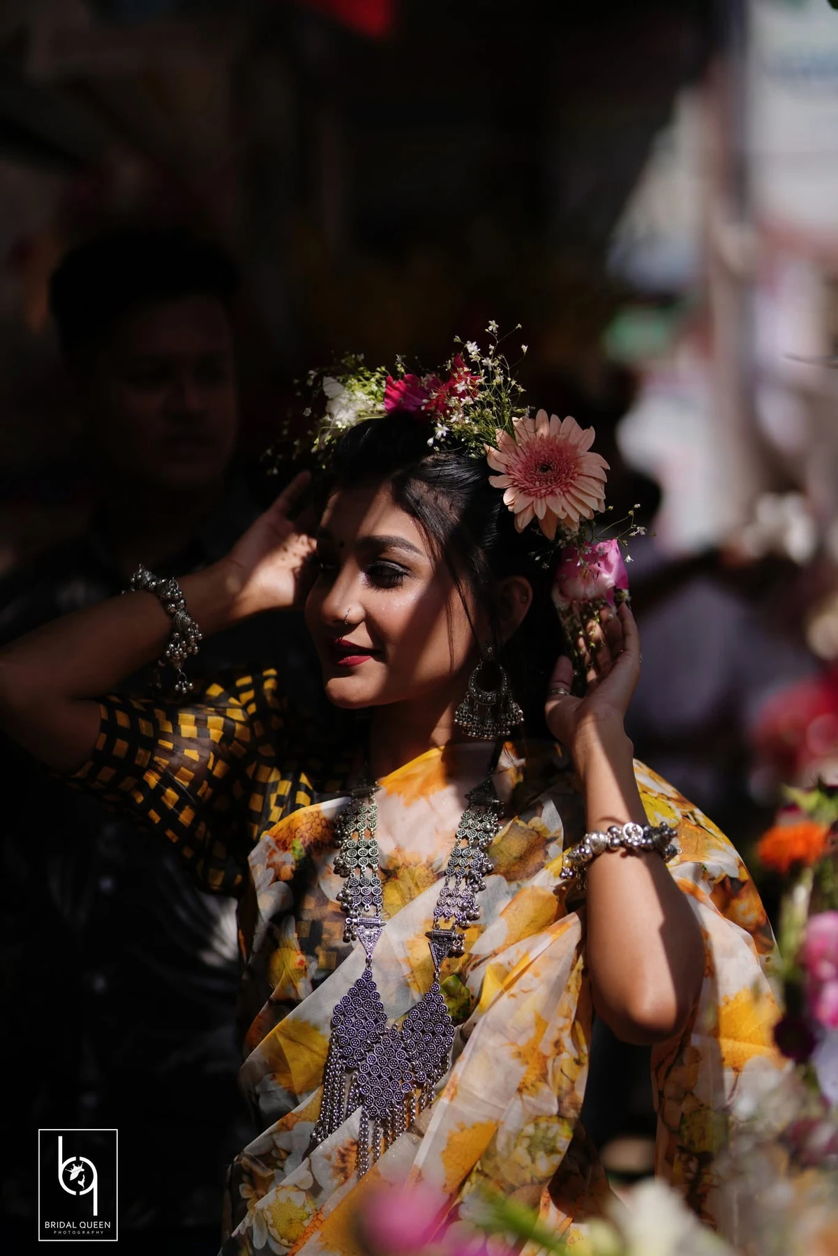 A bridal portrait with a floral hair arrangement, jewellery and warm directional light.